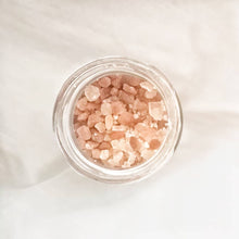 Muatkan imej ke dalam penonton Galeri, Top view of himalayan salt granules foot soak with rosemary on neutral background
